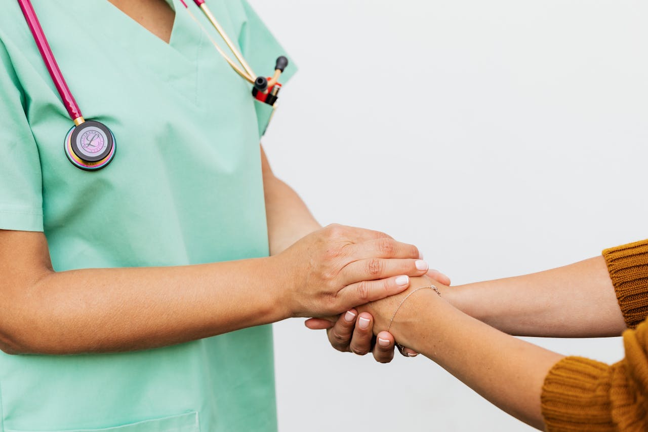 Close-up of a doctor holding a patients hands, symbolizing trust and empathy in healthcare.